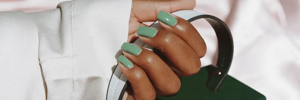 Green manicure and a leather bag